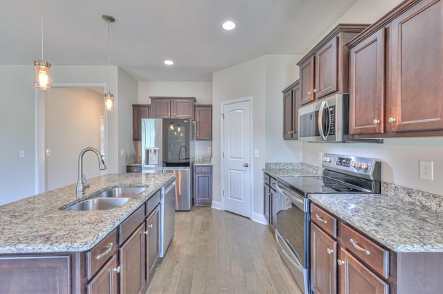 2009 Tulu Ct, Murfreesboro, TN 37128 - kitchen with stainless steel appliances, a sink, light wood-style floors, decorative light fixtures, and an island with sink