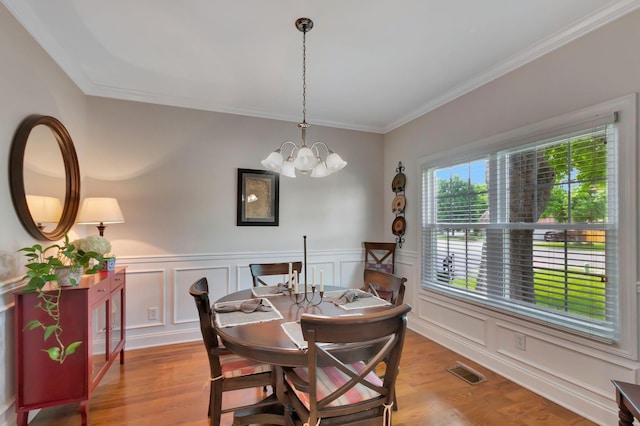 2710 Maylon Dr, Murfreesboro, TN 37128 - dining space featuring crown molding, a decorative wall, a chandelier, wood finished floors, and a wainscoted wall