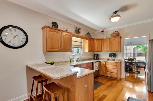 2710 Maylon Dr, Murfreesboro, TN 37128 - kitchen featuring stainless steel appliances, a peninsula, crown molding, a kitchen bar, and light wood-style flooring