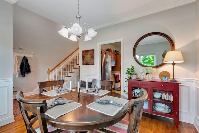 2710 Maylon Dr, Murfreesboro, TN 37128 - dining area featuring a chandelier, stairway, wood finished floors, ornamental molding, and a wainscoted wall