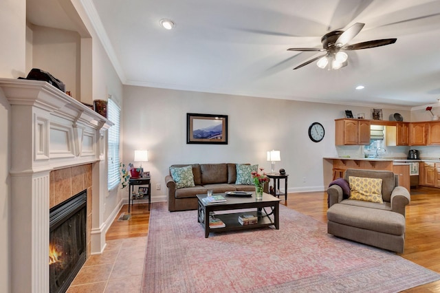 2710 Maylon Dr, Murfreesboro, TN 37128 - living area featuring a tiled fireplace, crown molding, a ceiling fan, recessed lighting, and light wood-style floors