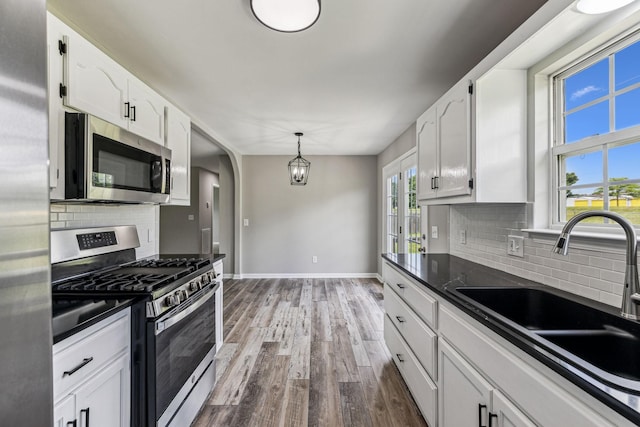 710 Krissy Ct, Columbia, TN 38401 - kitchen featuring stainless steel appliances, a sink, dark countertops, baseboards, and wood finished floors