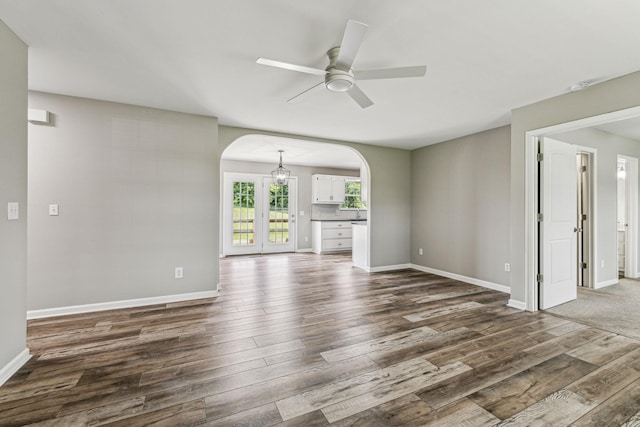 710 Krissy Ct, Columbia, TN 38401 - unfurnished living room featuring arched walkways, a ceiling fan, dark wood-type flooring, and baseboards