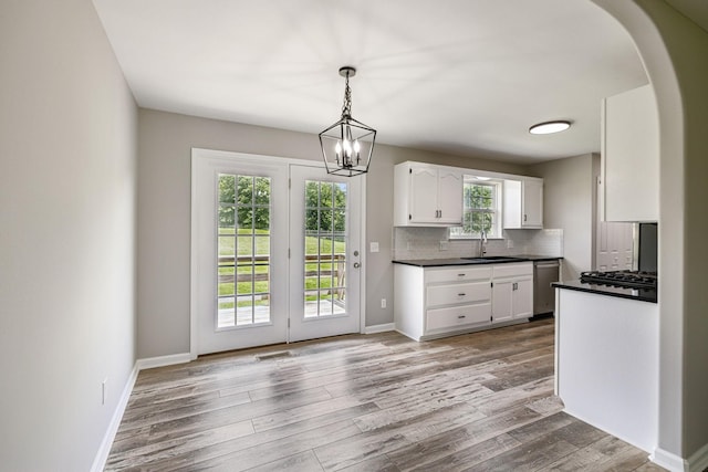 710 Krissy Ct, Columbia, TN 38401 - kitchen featuring a sink, dark countertops, white cabinetry, stainless steel dishwasher, and arched walkways