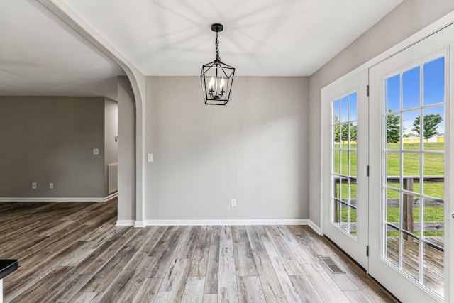 710 Krissy Ct, Columbia, TN 38401 - unfurnished dining area with baseboards, arched walkways, wood finished floors, and a chandelier