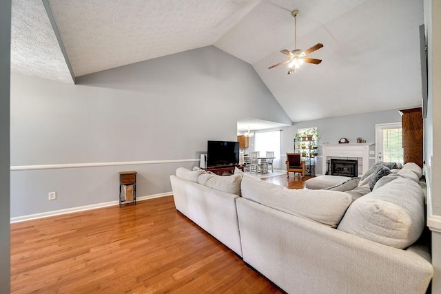 152 Cody Ct, Portland, TN 37148 - living area featuring a ceiling fan, light wood-style floors, a glass covered fireplace, baseboards, and high vaulted ceiling