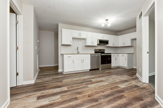 2640 Queen Anne Ct, Springfield, TN 37172 - kitchen with appliances with stainless steel finishes, white cabinetry, a sink, and wood finished floors