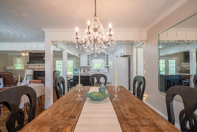 1448 Baker Ln, Lawrenceburg, TN 38464 - dining area featuring a ceiling fan, a fireplace, a chandelier, crown molding, and baseboards
