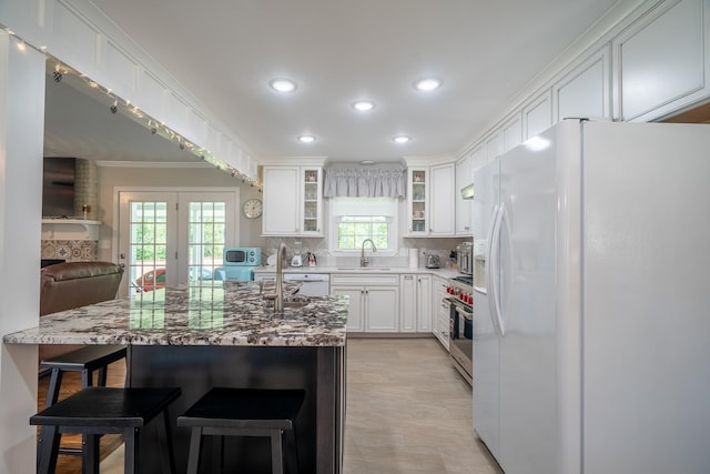 1448 Baker Ln, Lawrenceburg, TN 38464 - kitchen featuring white fridge with ice dispenser, a sink, high end stainless steel range, glass insert cabinets, and light stone countertops
