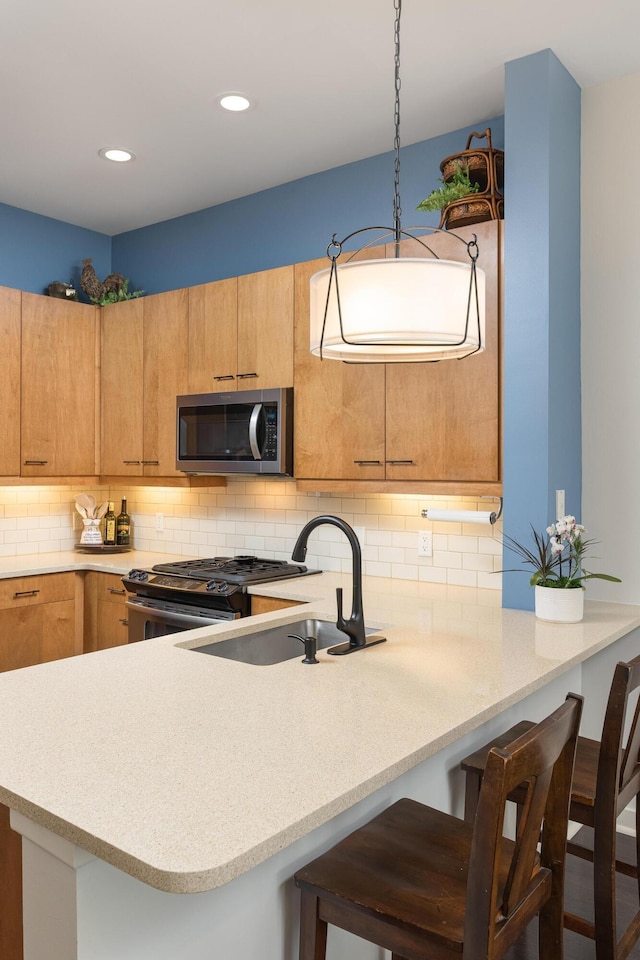 200 Manufacturers Rd Apt 241, Chattanooga, TN 37405 - kitchen with stainless steel appliances, light countertops, backsplash, a sink, and a kitchen breakfast bar