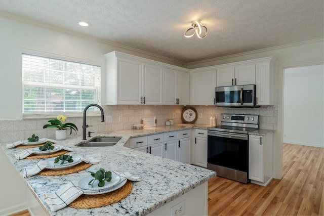 405 Parish Pl, Franklin, TN 37067 - kitchen featuring stainless steel appliances, a sink, white cabinets, decorative backsplash, and a textured ceiling