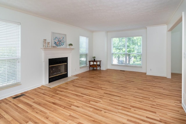 405 Parish Pl, Franklin, TN 37067 - living area featuring light wood-style flooring, ornamental molding, a glass covered fireplace, a textured ceiling, and baseboards