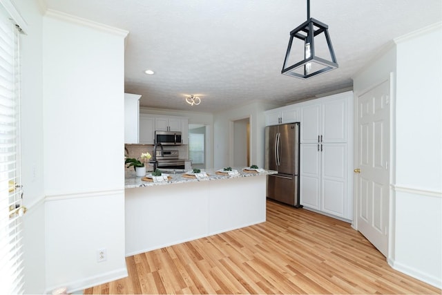 405 Parish Pl, Franklin, TN 37067 - kitchen featuring stainless steel appliances, light wood-style flooring, a peninsula, white cabinets, and ornamental molding