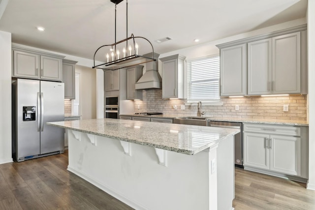 129 Willow Bend Dr, Mount Juliet, TN 37122 - kitchen featuring appliances with stainless steel finishes, gray cabinetry, a sink, a center island, and premium range hood