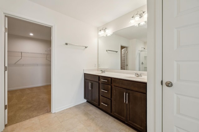 129 Willow Bend Dr, Mount Juliet, TN 37122 - bathroom with double vanity, a walk in closet, an enclosed shower, baseboards, and tile patterned floors