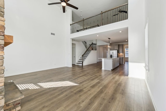129 Willow Bend Dr, Mount Juliet, TN 37122 - unfurnished living room featuring a ceiling fan, stairs, wood finished floors, a towering ceiling, and baseboards