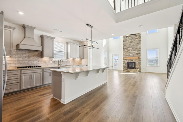 129 Willow Bend Dr, Mount Juliet, TN 37122 - kitchen featuring gray cabinets, a towering ceiling, premium range hood, plenty of natural light, and light stone countertops