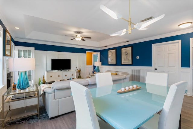 725 Forest Glen Cir, Murfreesboro, TN 37128 - dining space featuring a tray ceiling, wood finished floors, crown molding, a ceiling fan, and a wainscoted wall