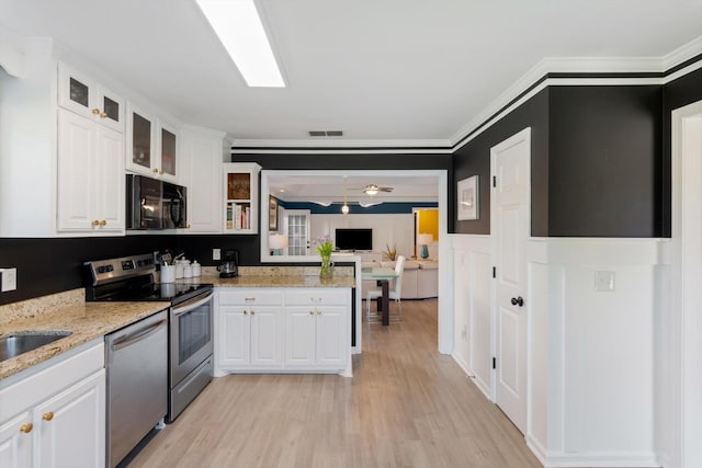 725 Forest Glen Cir, Murfreesboro, TN 37128 - kitchen featuring appliances with stainless steel finishes, light wood-type flooring, white cabinets, glass insert cabinets, and light stone counters