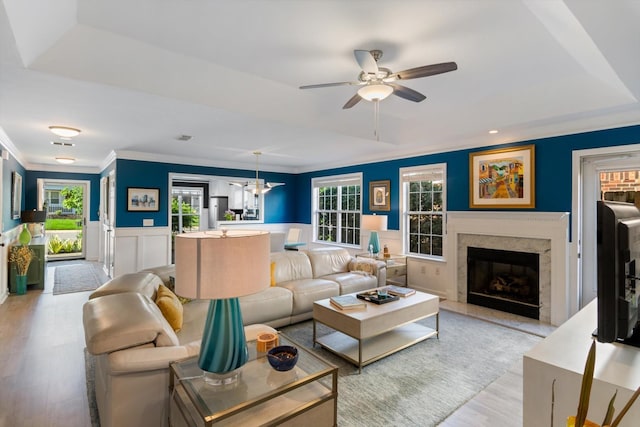 725 Forest Glen Cir, Murfreesboro, TN 37128 - living area featuring a ceiling fan, light wood-type flooring, crown molding, a premium fireplace, and wainscoting
