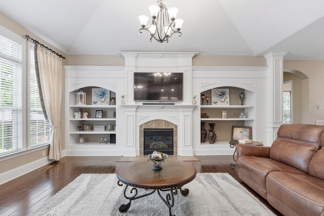 1237 Potter Ln, Gallatin, TN 37066 - living area featuring vaulted ceiling, dark wood-style flooring, arched walkways, a tiled fireplace, and built in features