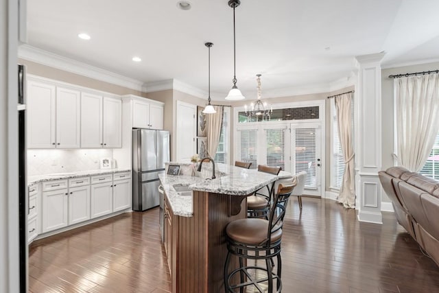 1237 Potter Ln, Gallatin, TN 37066 - kitchen featuring freestanding refrigerator, a sink, a kitchen bar, dark wood finished floors, and white cabinetry