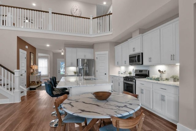 3608 Barbee Ct, Rockvale, TN 37153 - kitchen with appliances with stainless steel finishes, a sink, dark wood-style flooring, white cabinets, and a towering ceiling