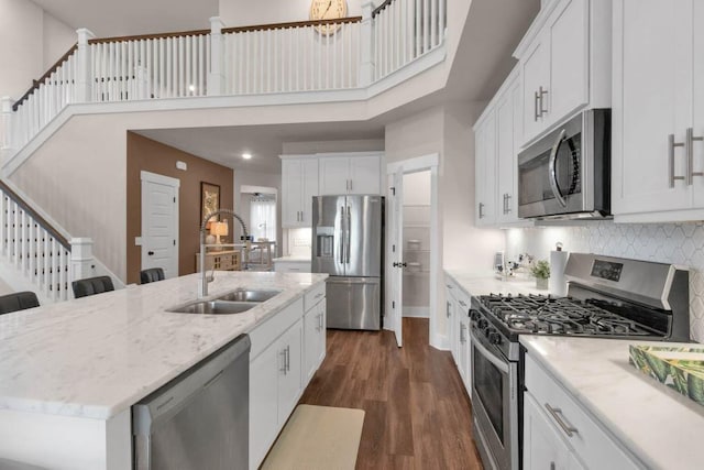 3608 Barbee Ct, Rockvale, TN 37153 - kitchen with stainless steel appliances, a sink, a high ceiling, dark wood-type flooring, and white cabinets