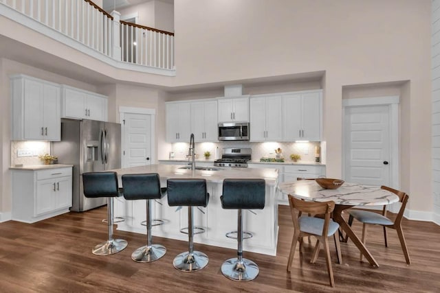 3608 Barbee Ct, Rockvale, TN 37153 - kitchen with appliances with stainless steel finishes, a high ceiling, a sink, tasteful backsplash, and white cabinets