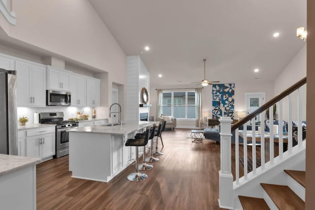 3608 Barbee Ct, Rockvale, TN 37153 - kitchen featuring appliances with stainless steel finishes, a sink, open floor plan, a ceiling fan, and white cabinets