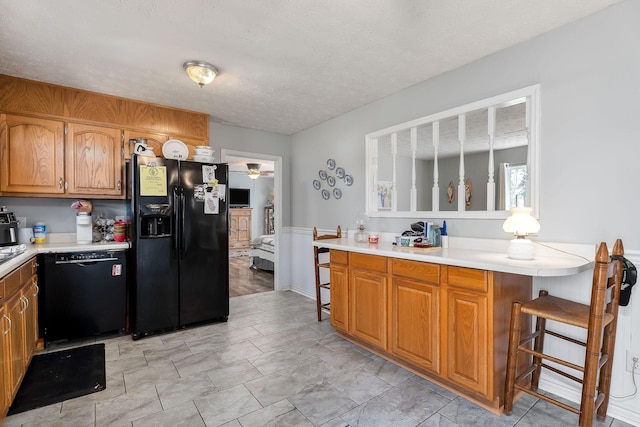 5024 Short Mountain Hwy, Smithville, TN 37166 - kitchen with black appliances, light countertops, a ceiling fan, wainscoting, and a textured ceiling