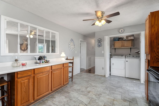 5024 Short Mountain Hwy, Smithville, TN 37166 - kitchen featuring a ceiling fan, washer and dryer, light countertops, brown cabinets, and a textured ceiling