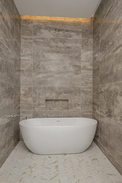 1030 17th Ave S Unit 201, Nashville, TN 37212 - full bathroom featuring a soaking tub, marble finish floors, and tile walls