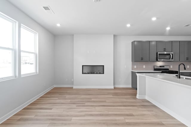 283 Subban Ct, Lebanon, TN 37087 - kitchen featuring appliances with stainless steel finishes, gray cabinetry, a sink, recessed lighting, and light wood-style floors