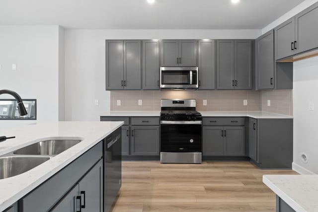 283 Subban Ct, Lebanon, TN 37087 - kitchen with stainless steel appliances, a sink, gray cabinets, and light stone counters
