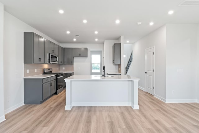 283 Subban Ct, Lebanon, TN 37087 - kitchen with appliances with stainless steel finishes, gray cabinetry, a sink, light wood-type flooring, and tasteful backsplash