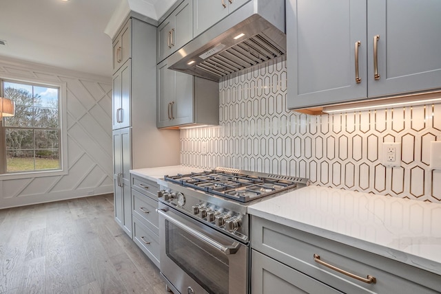 5405 Manners Rd, Lebanon, TN 37087 - kitchen featuring extractor fan, high end range, gray cabinetry, light wood finished floors, and decorative backsplash