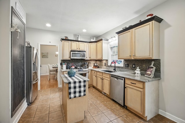 3198 Gray Hawk Ct, Clarksville, TN 37043 - kitchen with appliances with stainless steel finishes, decorative backsplash, light brown cabinetry, a kitchen island, and light countertops
