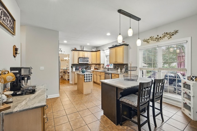 3198 Gray Hawk Ct, Clarksville, TN 37043 - kitchen featuring stainless steel appliances, light brown cabinets, light tile patterned floors, decorative backsplash, and a kitchen island