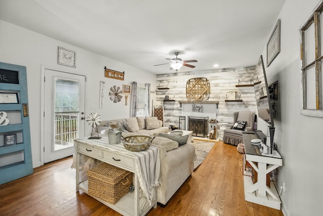3198 Gray Hawk Ct, Clarksville, TN 37043 - living area featuring a fireplace with raised hearth, ceiling fan, and wood finished floors