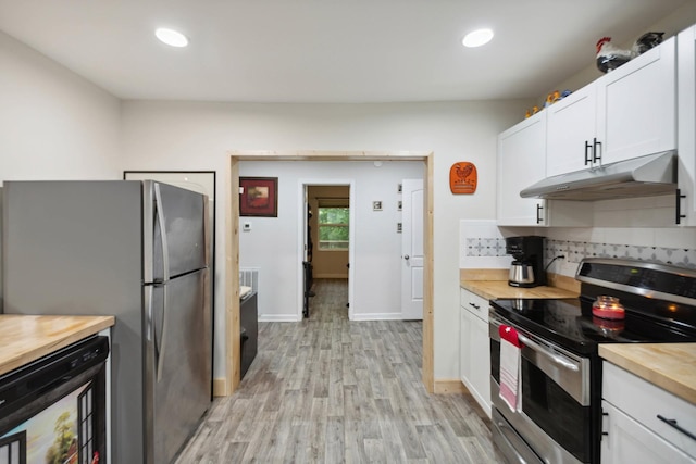 1602 Pleasant Grove Rd, Westmoreland, TN 37186 - kitchen with appliances with stainless steel finishes, under cabinet range hood, butcher block countertops, light wood-type flooring, and decorative backsplash