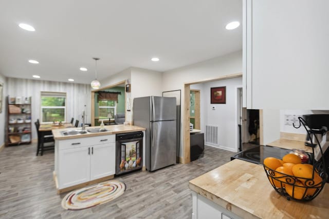 1602 Pleasant Grove Rd, Westmoreland, TN 37186 - kitchen featuring freestanding refrigerator, a sink, light wood-style flooring, white cabinets, and recessed lighting