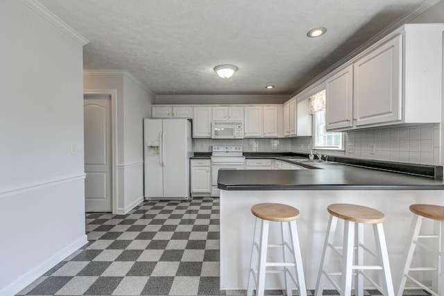 206 Sayre Ln, Murfreesboro, TN 37127 - kitchen featuring white appliances, dark countertops, dark flooring, a peninsula, and baseboards