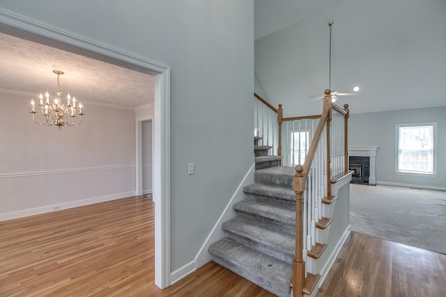 206 Sayre Ln, Murfreesboro, TN 37127 - stairway featuring a chandelier, a fireplace, baseboards, wood finished floors, and ornamental molding