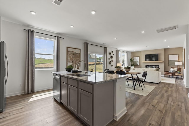 2502 Beverly Gail Rd, Pleasant View, TN 37146 - kitchen featuring appliances with stainless steel finishes, a sink, a fireplace, gray cabinetry, and dark wood finished floors
