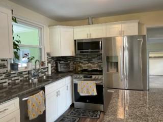 904 Apple Valley Rd, Madison, TN 37115 - kitchen featuring appliances with stainless steel finishes, white cabinetry, tasteful backsplash, and dark stone countertops
