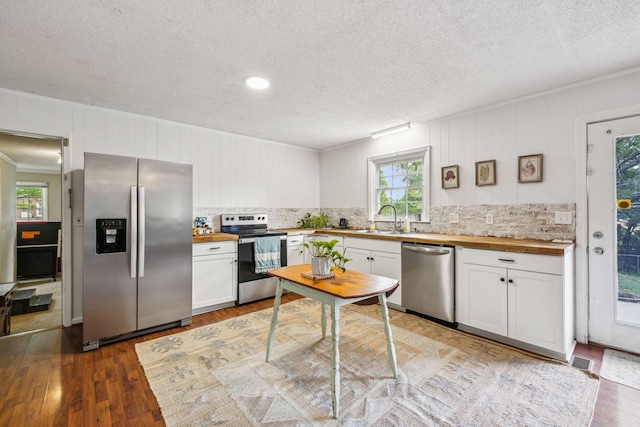 979 S Main St S, Eagleville, TN 37060 - kitchen with appliances with stainless steel finishes, wooden counters, a sink, a textured ceiling, and wood finished floors