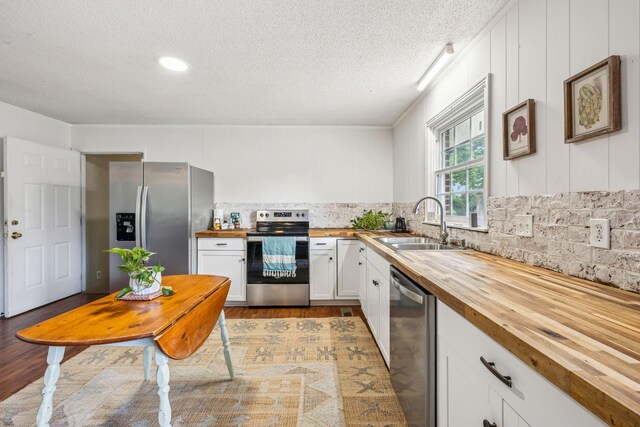 979 S Main St S, Eagleville, TN 37060 - kitchen with butcher block counters, stainless steel appliances, a sink, light wood-style flooring, and white cabinets