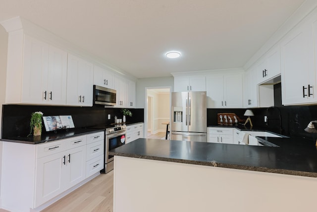 1405 SE Broad St, Murfreesboro, TN 37130 - kitchen featuring stainless steel appliances, dark countertops, tasteful backsplash, a peninsula, and light wood-style flooring
