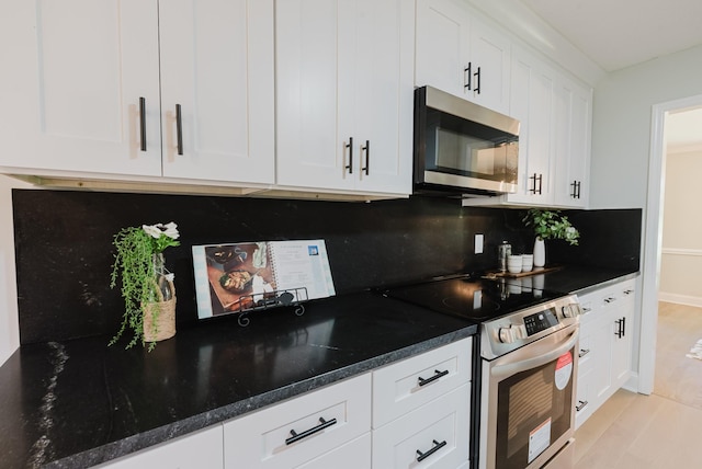 1405 SE Broad St, Murfreesboro, TN 37130 - kitchen with stainless steel appliances, tasteful backsplash, white cabinetry, baseboards, and dark stone countertops